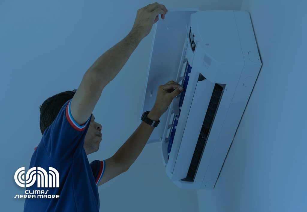 Profesional realizando la instalación de un minisplit en una pared de una casa.